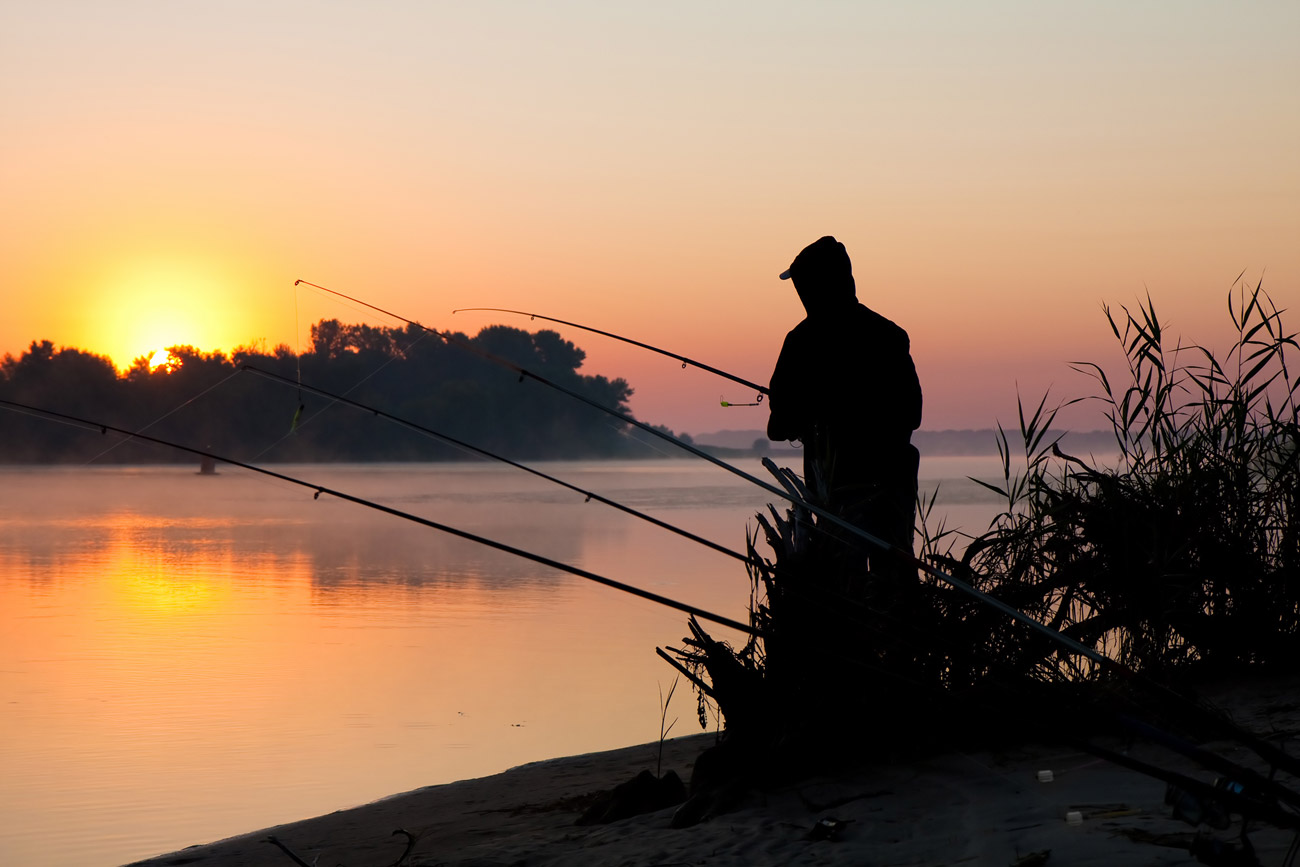 Silhouette of a man fishing in a sunset